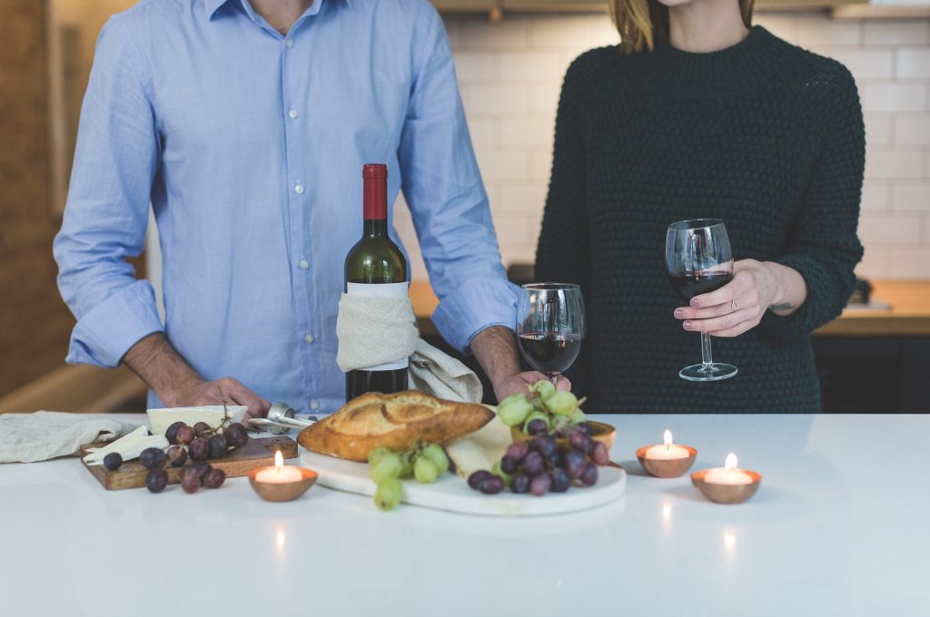 Duas pessoas jantando com um bom vinho e vários acompanhamentos