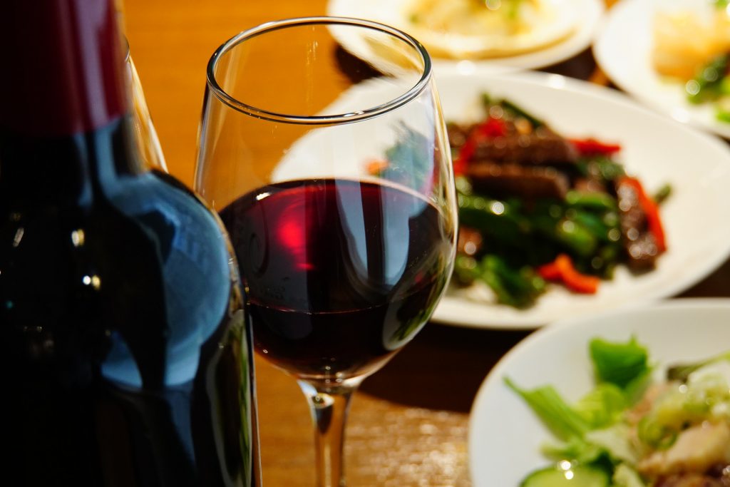 Garrafa e taça de vinho com pratos de comida