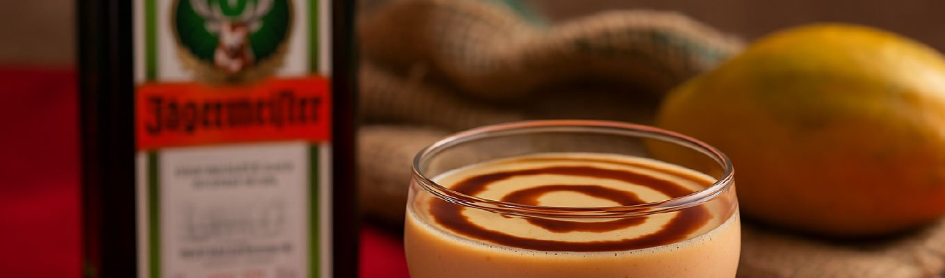 Taça de creme de papaia com Jägermeister decorado em fundo neutro