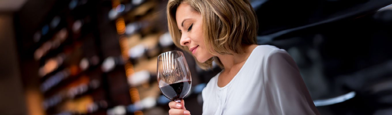 Pessoa sentindo aromas do vinho na taça para despertar o paladar